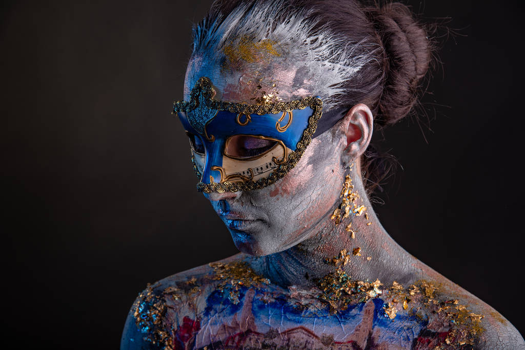 Πορτραίτο μιας νεαρής μασκοφόρου γυναίκας με δημιουργικό μακιγιάζ στο θέμα του καρναβαλιού της Βενετίας - Φωτογραφία, εικόνα