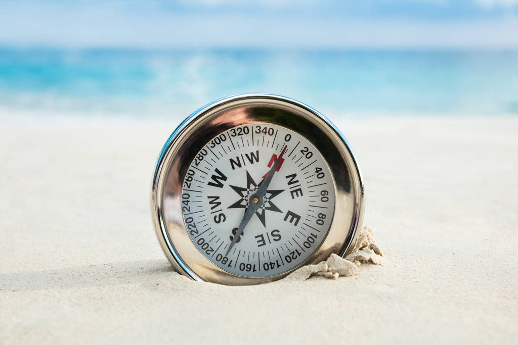 Zbliżenie Złotego kompasu Zakopanego na piaszczystej plaży - Zdjęcie, obraz
