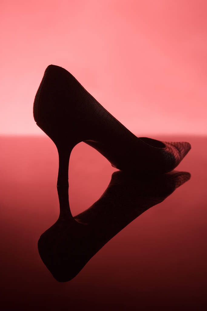 Θηλυκό παπούτσι σε κόκκινο φόντο - Φωτογραφία, εικόνα