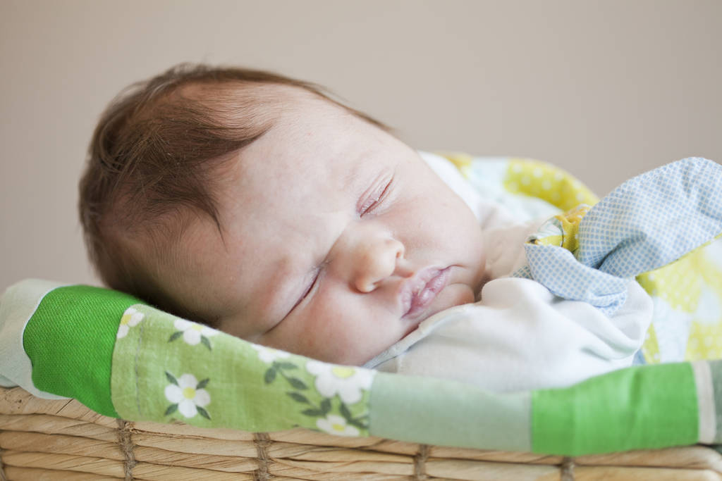 Портрет милой новорожденной девочки, спящей в корзине
 - Фото, изображение