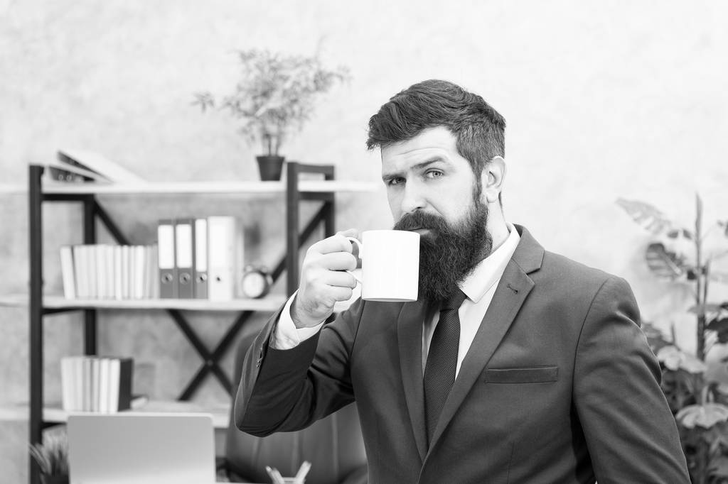 Mies parrakas liikemies pidä kahvikuppi seistä toimistotausta. Aloita päivä kahvilla. Onnistuneet ihmiset juovat kahvia. Kahvin juominen rentouttava tauko. Pomo nauttii energiajuomasta. Kofeiiniriippuvainen
 - Valokuva, kuva