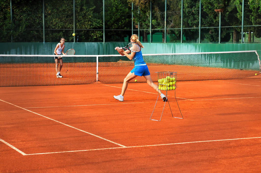 Dvě mladé ženy hrají tenis venku na hřišti - Fotografie, Obrázek