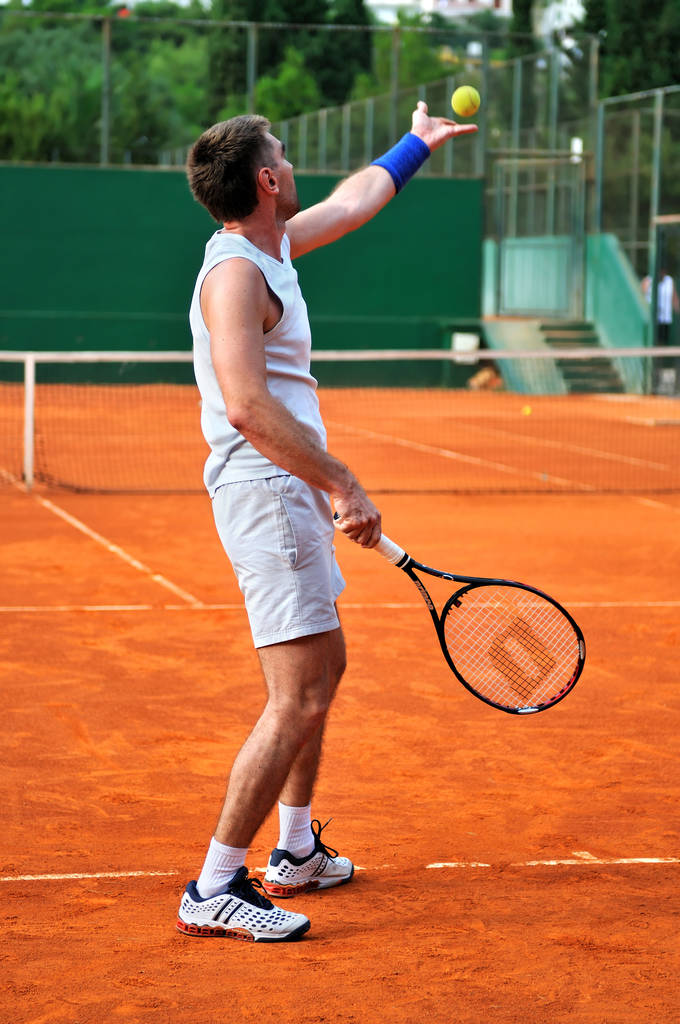 Ein Mann spielt Tennis auf dem Außenplatz - Foto, Bild