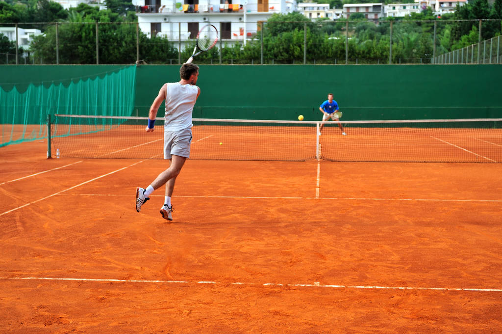 Un hombre juega al tenis en la cancha exterior - Foto, Imagen