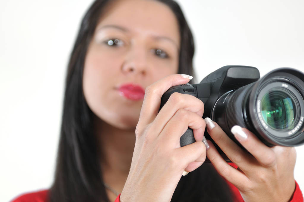 Νεαρή γυναίκα κρατώντας φωτογραφική μηχανή στο χέρι λήψη εικόνα απομονωμένη - Φωτογραφία, εικόνα