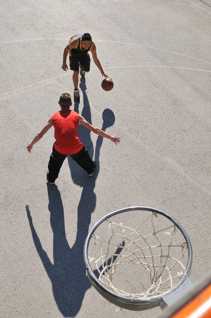 Gorup de chicos jóvenes que juegan baloncesto al aire libre en la calle con largas sombras y perspectiva de vista de pájaro
 - Foto, imagen