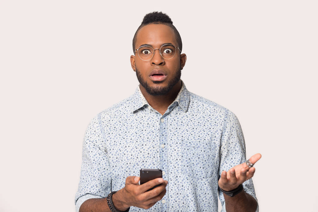 Surprised black man confused by unexpected message on smartphone - Photo, Image