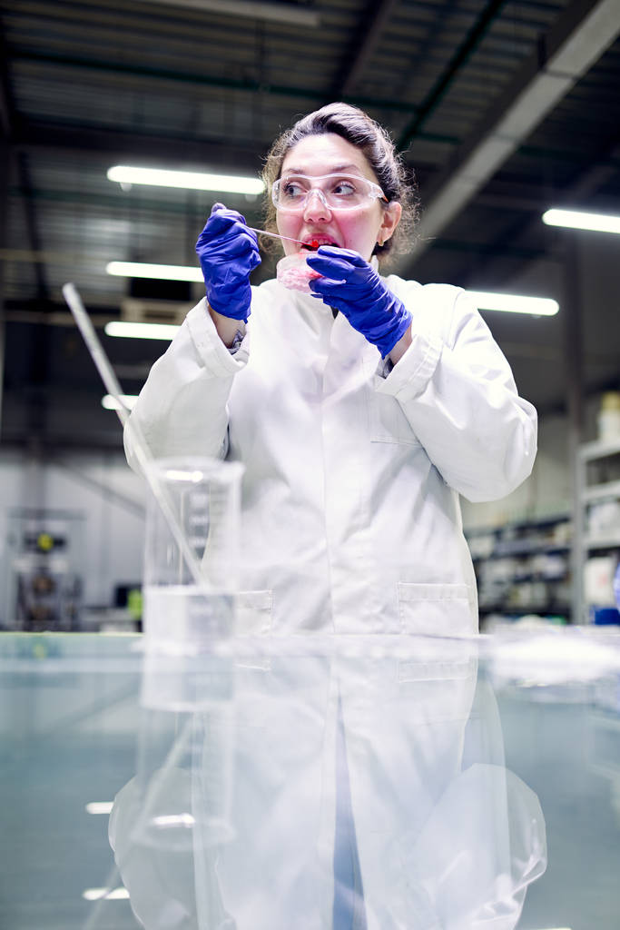 メガネとペトリ皿を手にした実験室の女性が実験を行う - 写真・画像