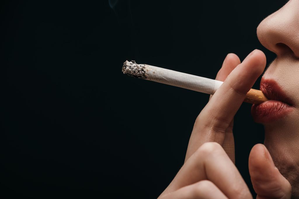 Vista lateral da mulher fumando cigarro isolado em preto
  - Foto, Imagem
