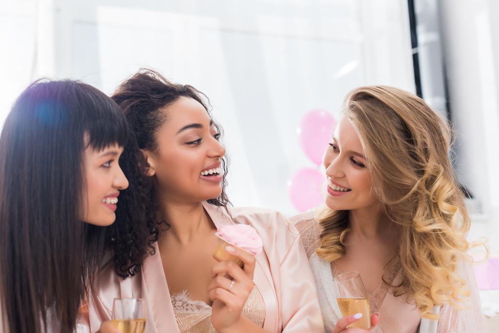 Güzel, çok kültürlü kızlar bekarlığa veda partisinde şampanya ve çörekle eğleniyorlar.  - Fotoğraf, Görsel