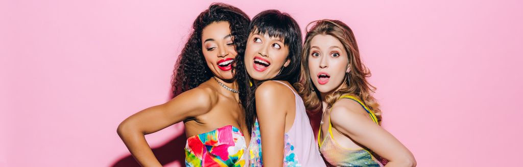 tiro panorâmico de belas namoradas multiculturais na moda posando em rosa
 - Foto, Imagem