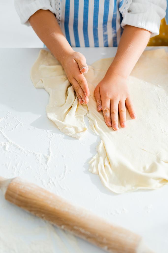vista cortada de filha cozinhando massa para pastelaria na mesa
  - Foto, Imagem
