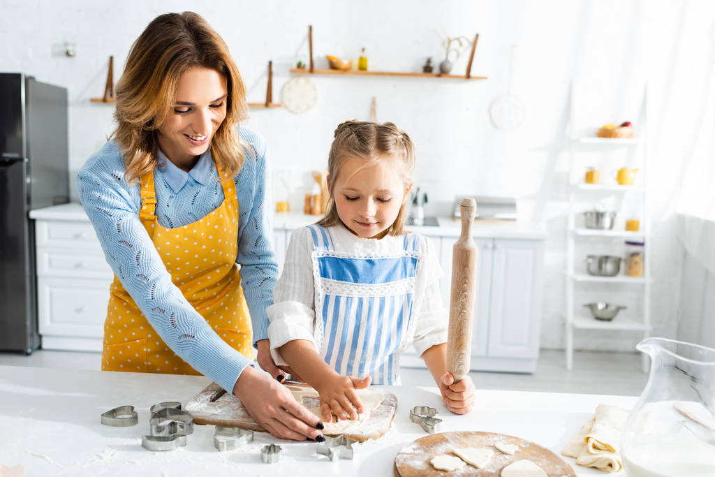 sorridente mãe e bonito filha cozinhar biscoitos na cozinha
  - Foto, Imagem