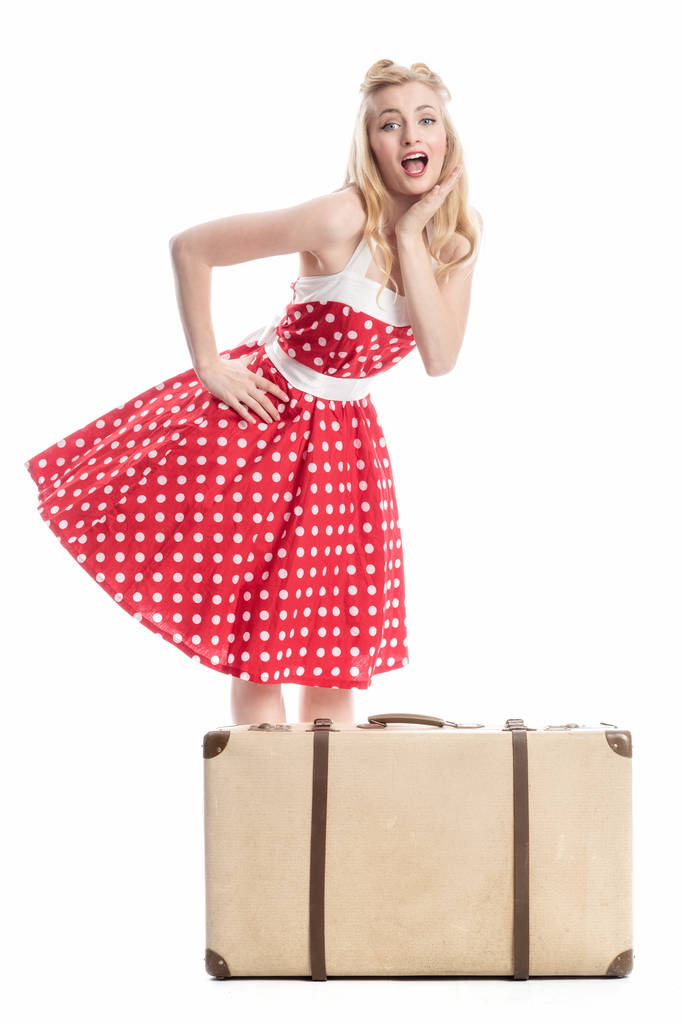 una mujer sorprendida en vestido de verano de pie detrás de una maleta
 - Foto, Imagen