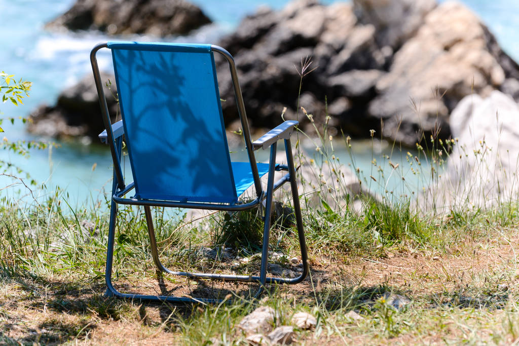 μπλε άδεια πτυσσόμενη καρέκλα στην κροατική ακτή - Φωτογραφία, εικόνα