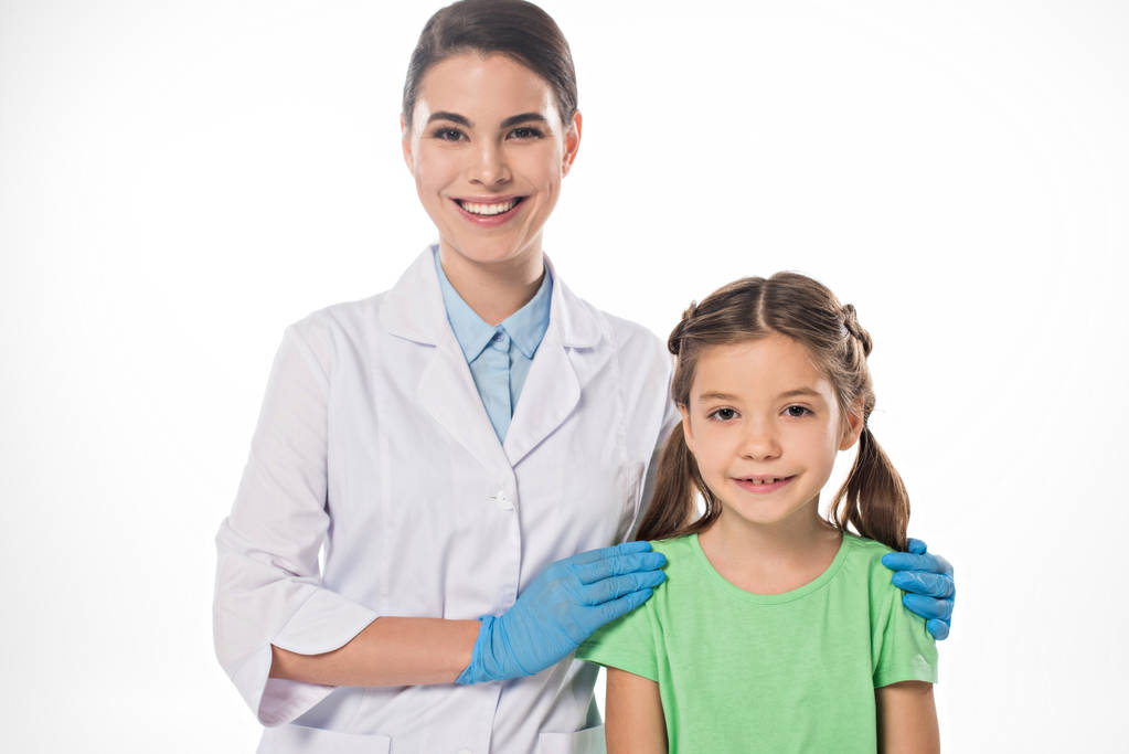 Pediatrician hugging kid and smiling at camera isolated on white - Photo, Image