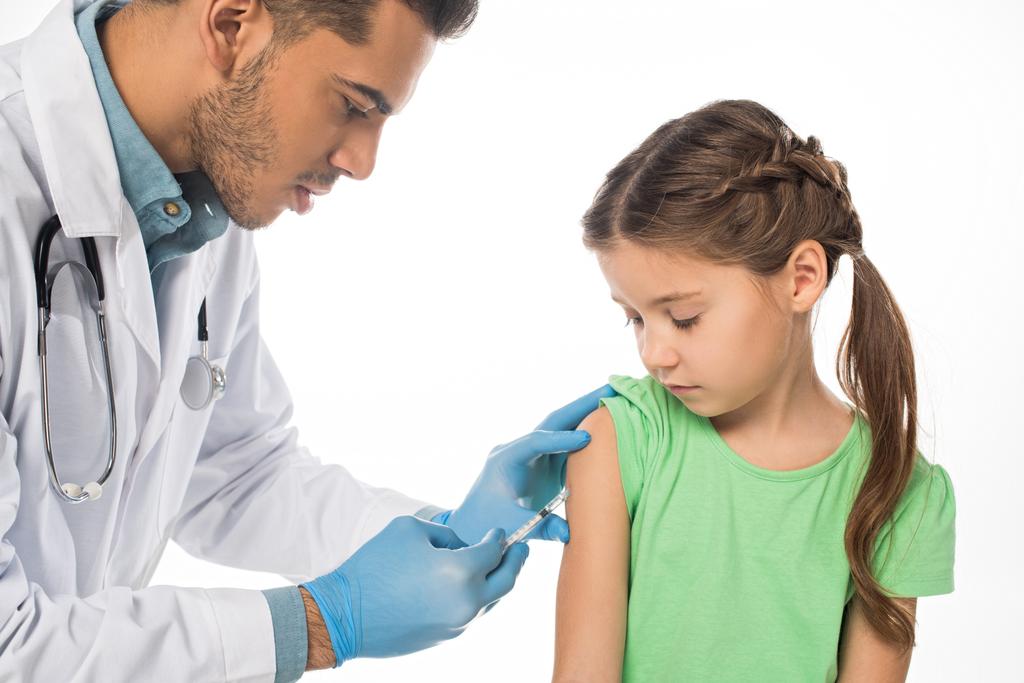 Pediatra che fa l'iniezione del vaccino al bambino isolato su bianco
 - Foto, immagini