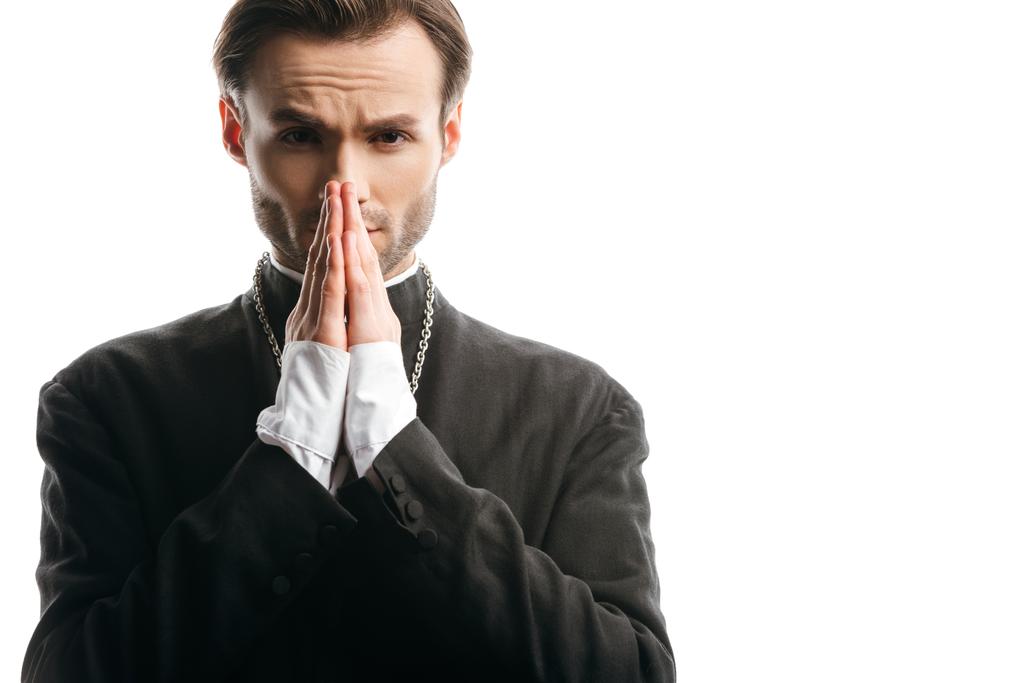 serious, concentrated catholic priest praying while looking at camera isolated on white - Photo, Image