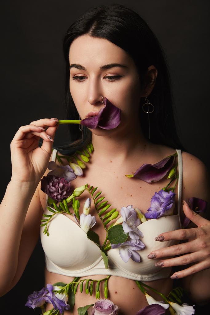beautiful girl in bra with violet and purple flowers on body isolated on black - Photo, Image