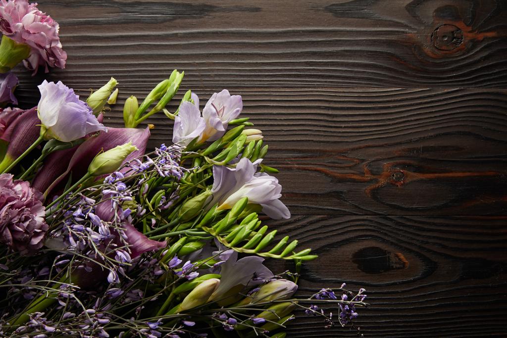 vista superior del ramo floral violeta y púrpura en la mesa de madera
 - Foto, Imagen