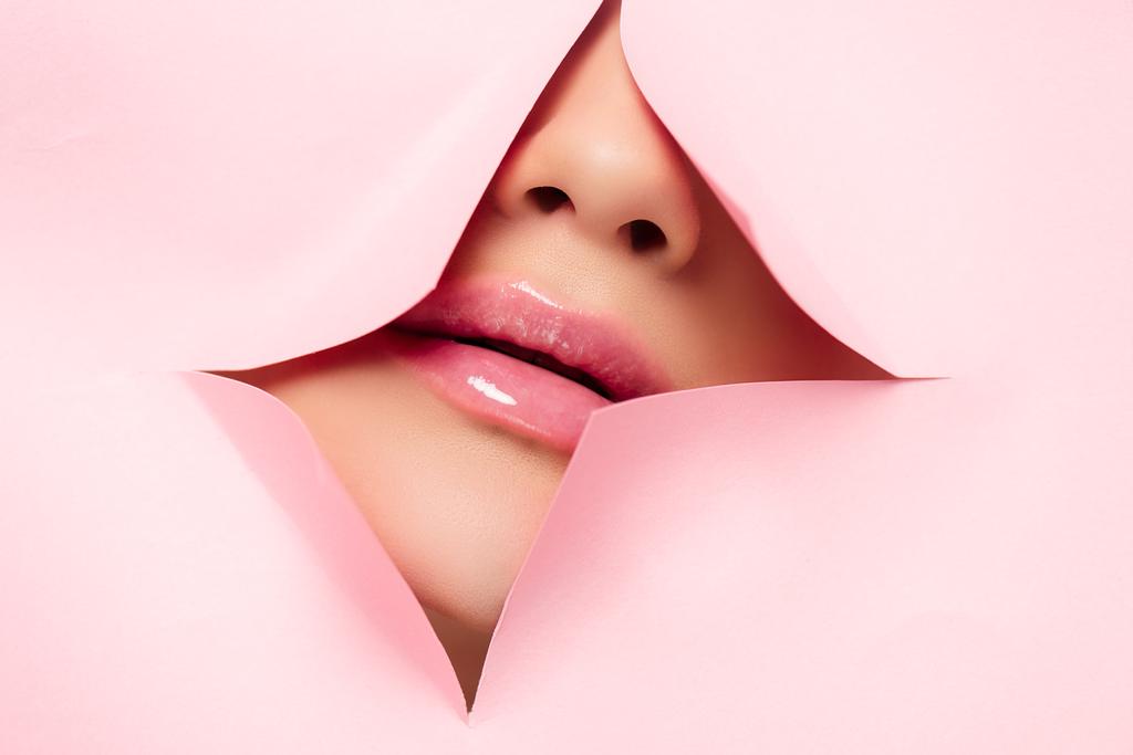 cropped view of girl showing pink lips in torn paper  - Photo, Image