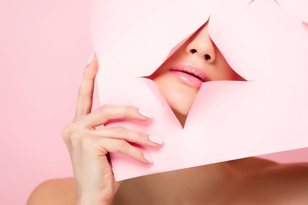 kaunis alaston tyttö osoittaa vaaleanpunainen huulet revitty paperi, eristetty vaaleanpunainen
 - Valokuva, kuva