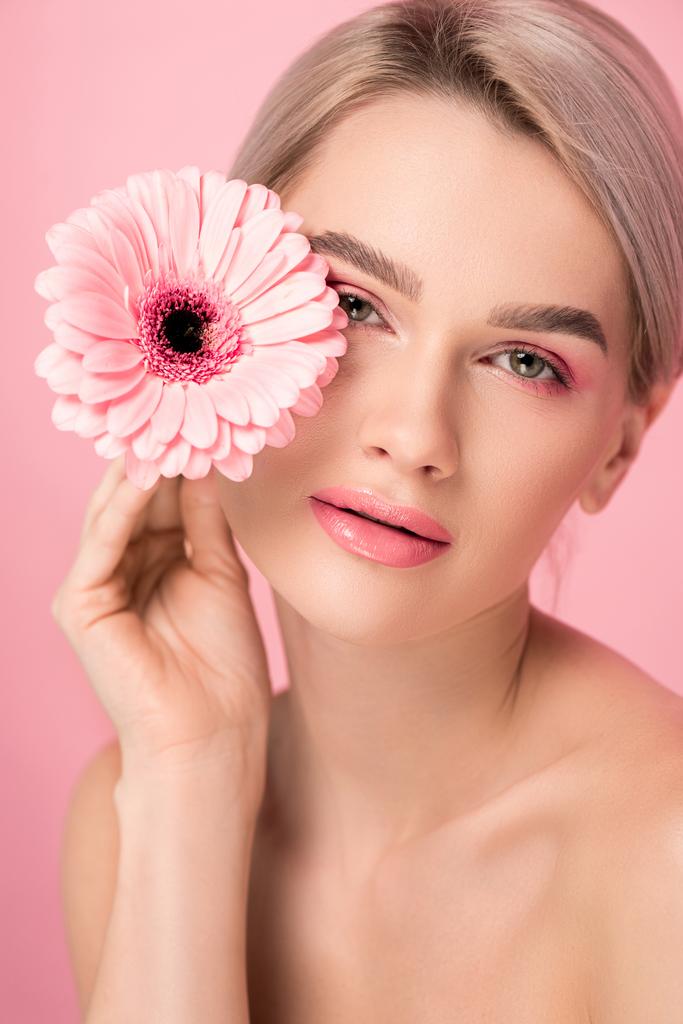 tierna mujer desnuda con maquillaje rosa sosteniendo flor de gerberas, aislado en rosa
 - Foto, imagen