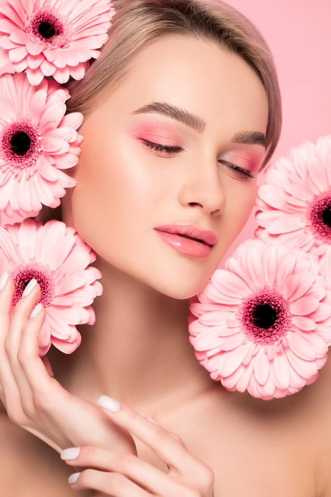 attractive tender girl with pink makeup and gerbera flowers, isolated on pink - Photo, Image