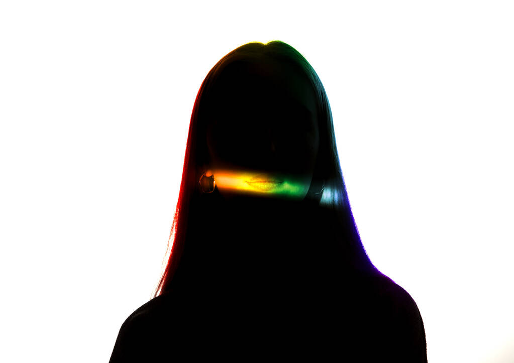 Portrait dramatique d'une fille dans l'obscurité sur fond de studio blanc avec ligne de couleur arc-en-ciel
 - Photo, image