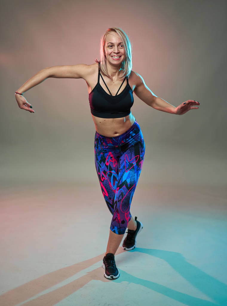 Fitness μοντέλο κάνει αερόβιες ασκήσεις και χορό, στούντιο πυροβόλησε - Φωτογραφία, εικόνα