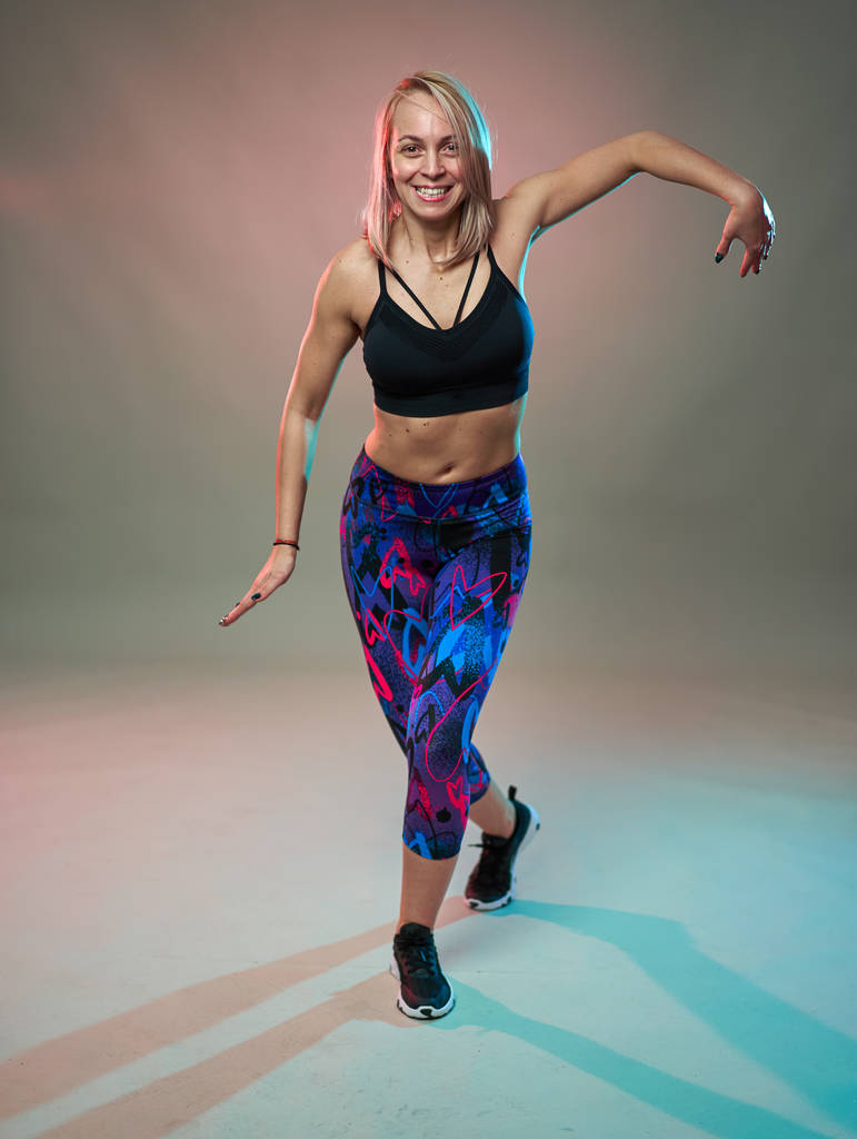 Fitness model dělá aerobní cvičení a tanec, studio shot - Fotografie, Obrázek