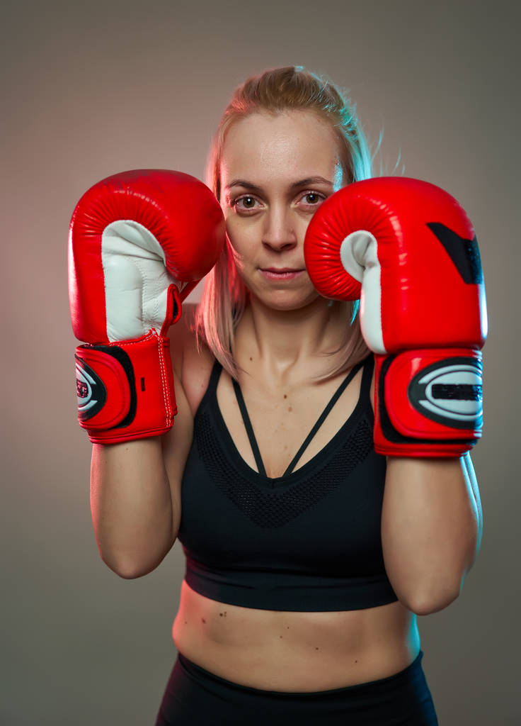 Боксерська дівчина з тренуванням червоних рукавичок, студійний знімок
 - Фото, зображення