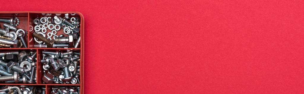 Κάτοψη εργαλειοθήκης με παξιμάδια και βίδες ξύλου σε κόκκινο φόντο, πανοραμική λήψη - Φωτογραφία, εικόνα
