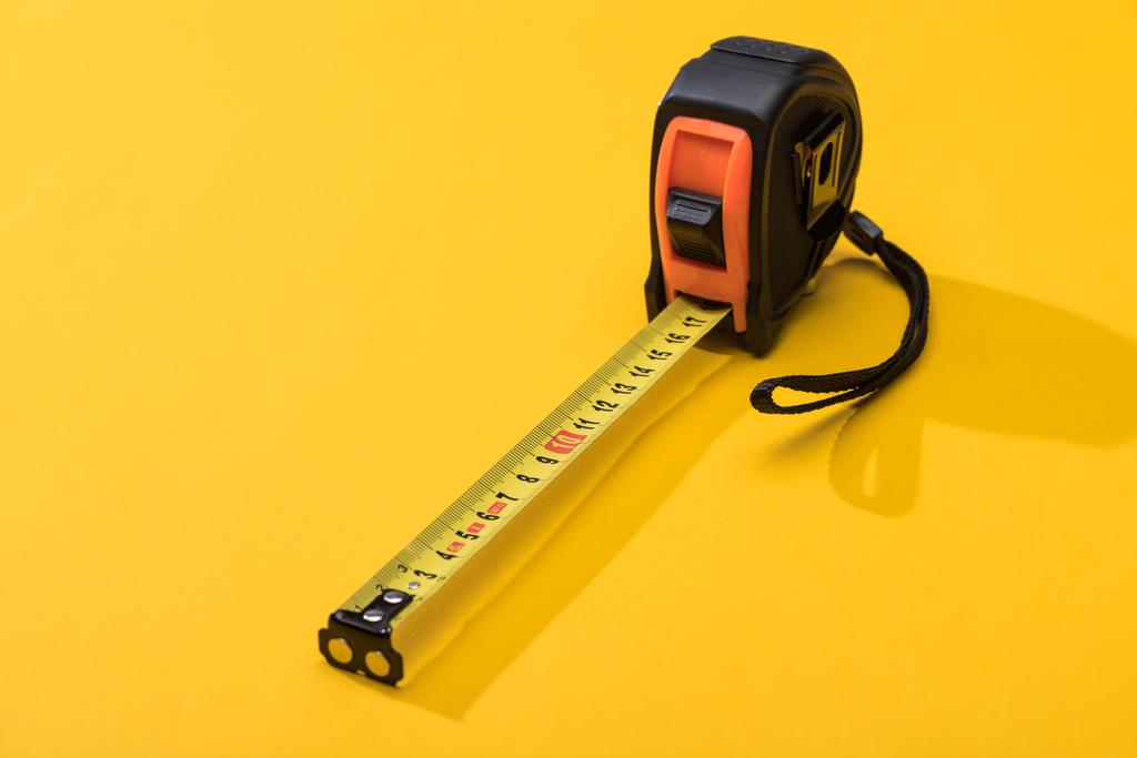 Industrial measuring tape with shadow on yellow background - Photo, Image