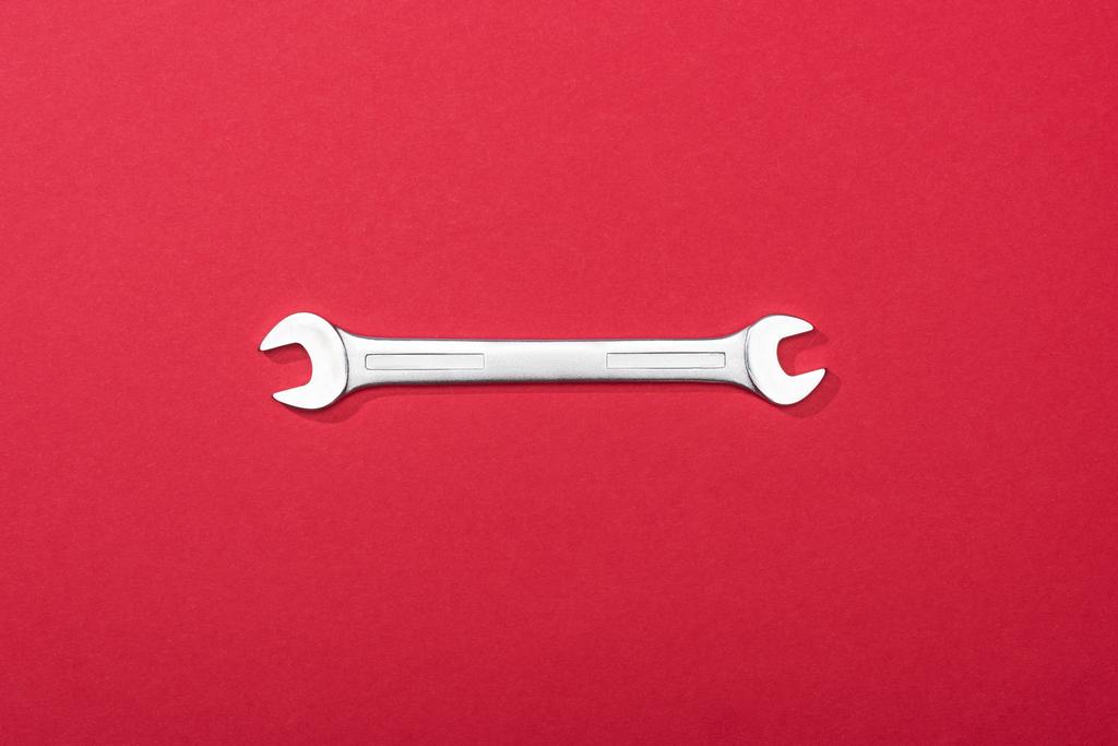 Kırmızı arkaplanda metal anahtarın üst görünümü - Fotoğraf, Görsel