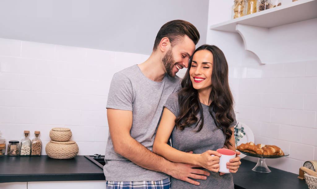 szczęśliwa para z kawą w kuchni w domu - Zdjęcie, obraz
