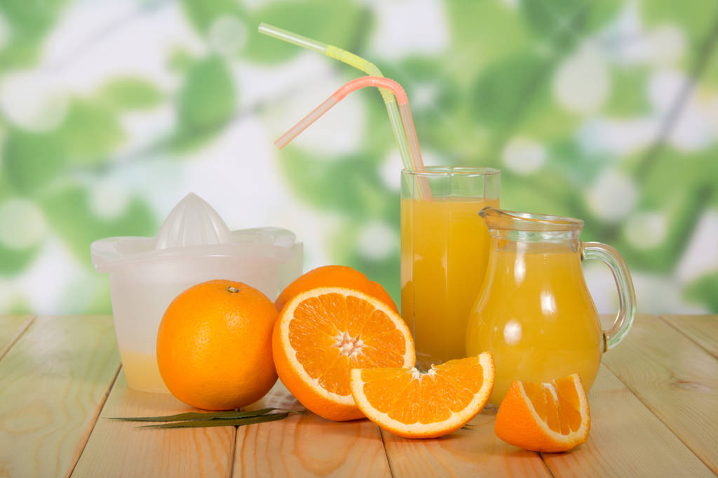 Апельсин і глечик з соком на дерев'яному столі
 - Фото, зображення