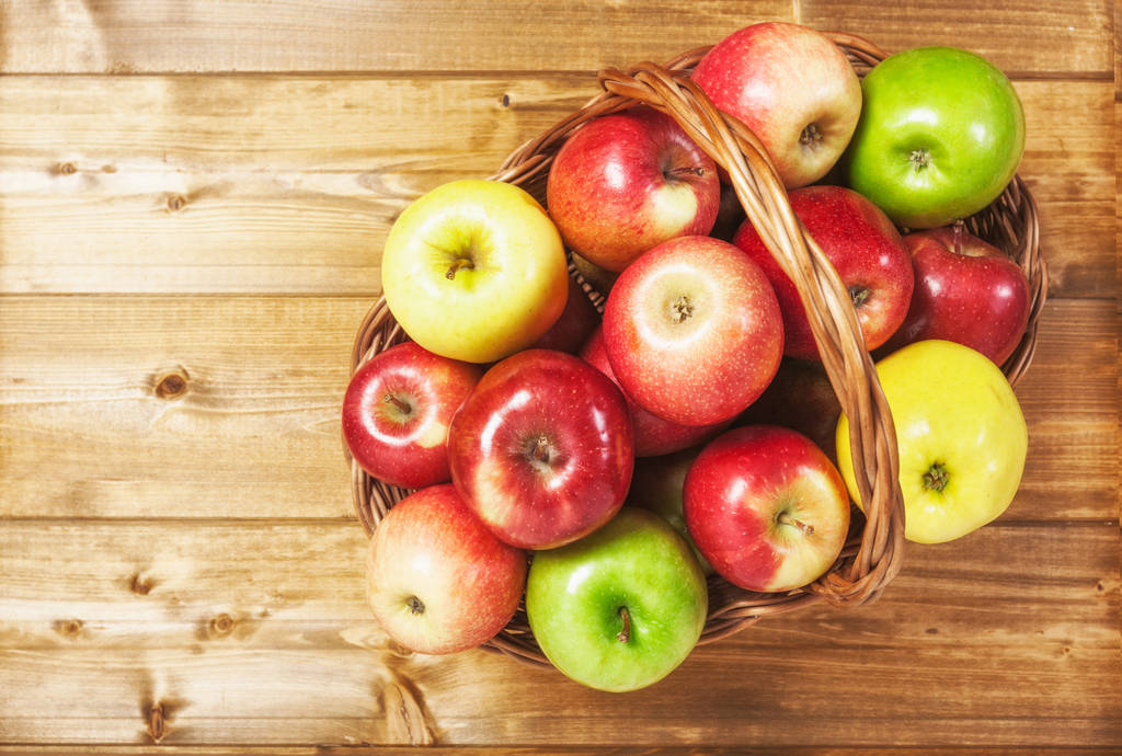 Korb mit Apfelfrüchten auf Holzuntergrund. Gesunde Ernährung und Diätkonzept. Wintersortiment. Kopierraum. Ansicht von oben - Foto, Bild