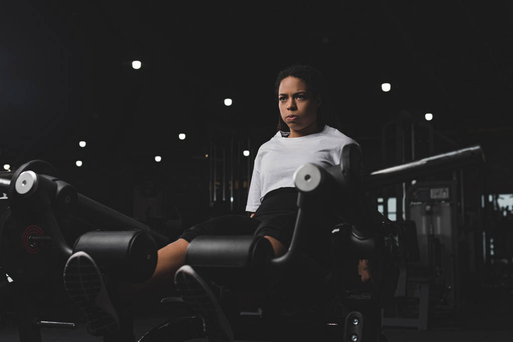 Enfoque selectivo de la mujer afroamericana haciendo ejercicio para abdominales en el gimnasio
 - Foto, imagen