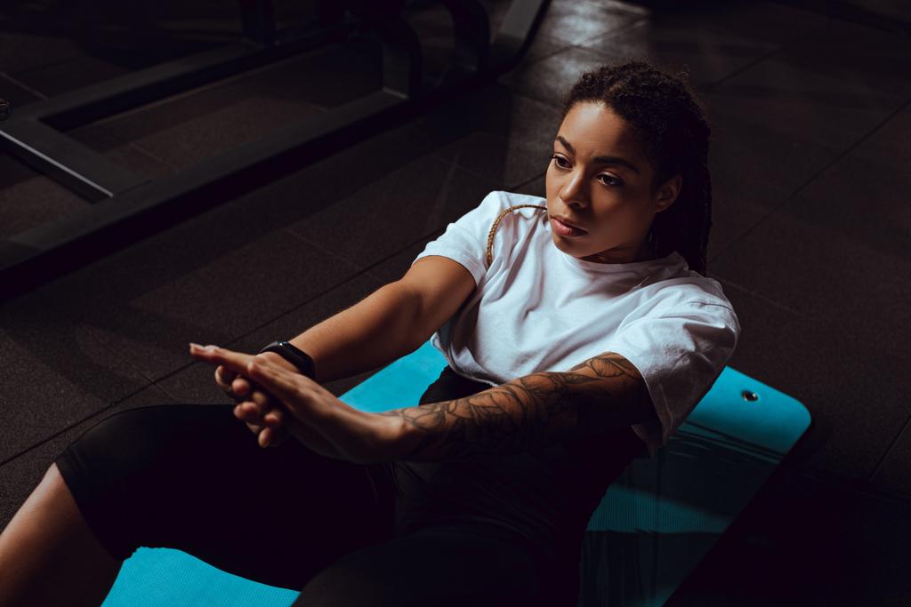 tattooed african american woman doing exercise on fitness mat - Photo, Image