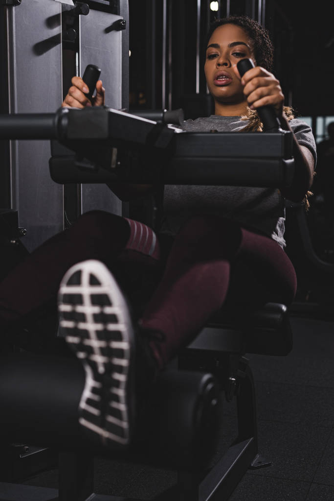 foco seletivo da menina americana africana trabalhando na máquina de ginásio
 - Foto, Imagem