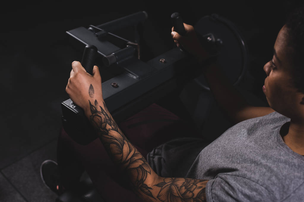 foyer sélectif de femme afro-américaine tatouée faisant de l'exercice sur un appareil de fitness
 - Photo, image