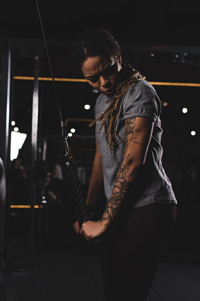 nuori afrikkalainen amerikkalainen nainen tatuointi käyttäessään kuntosalilla
  - Valokuva, kuva