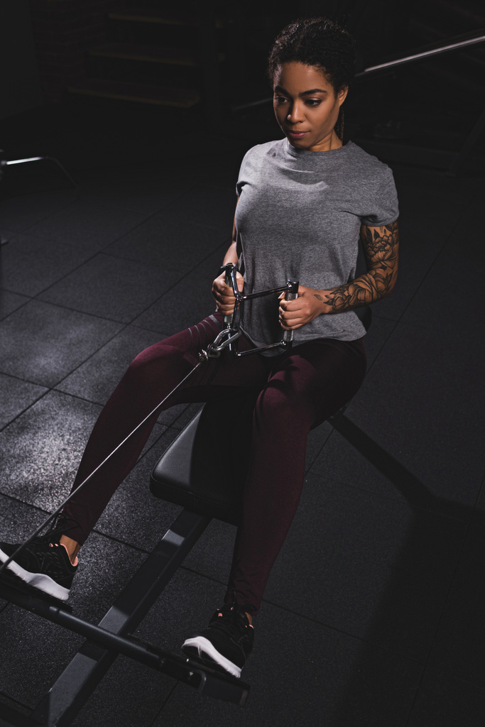 atlético afro-americano menina com tatuagem exercício no ginásio
  - Foto, Imagem