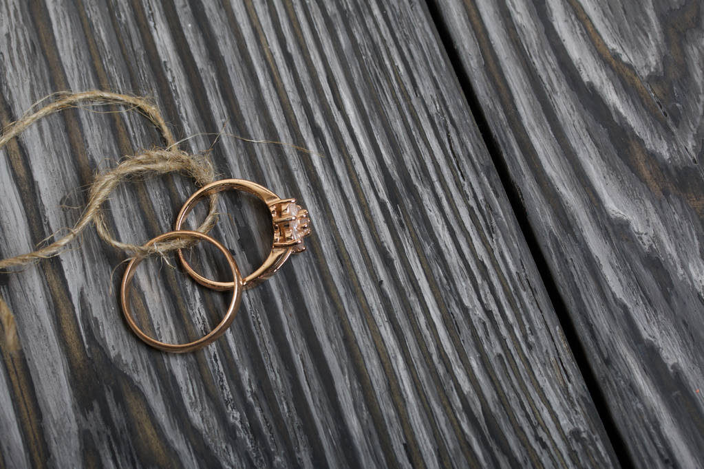 Svatební prsteny svázané provazem. Na kartáčovaných borovicových prknech malovaných černobíle. - Fotografie, Obrázek