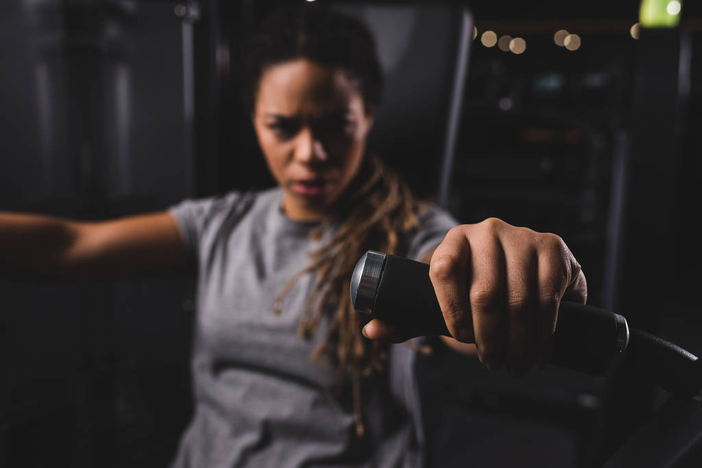 selectieve focus van aantrekkelijke Afrikaans Amerikaans meisje oefenen op sportschool machine  - Foto, afbeelding