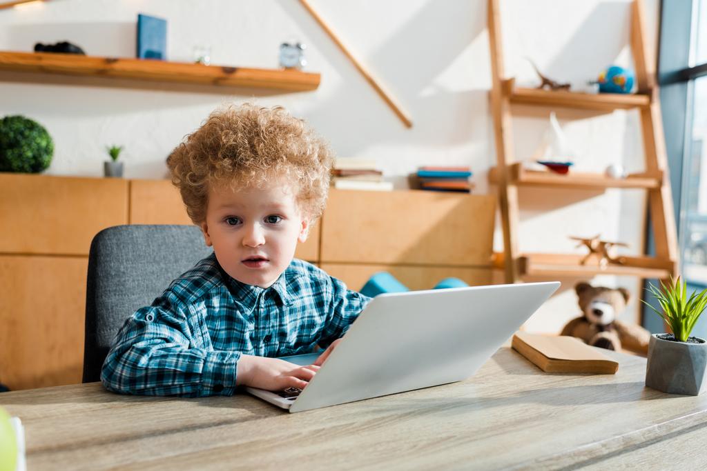 Nettes und intelligentes Kind mit Laptop und Kamera  - Foto, Bild