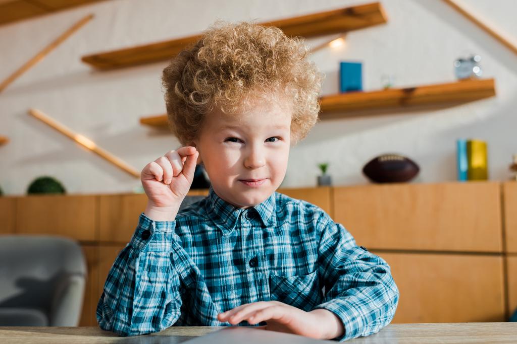 happy and curly kid gesturing while looking at camera  - Photo, Image