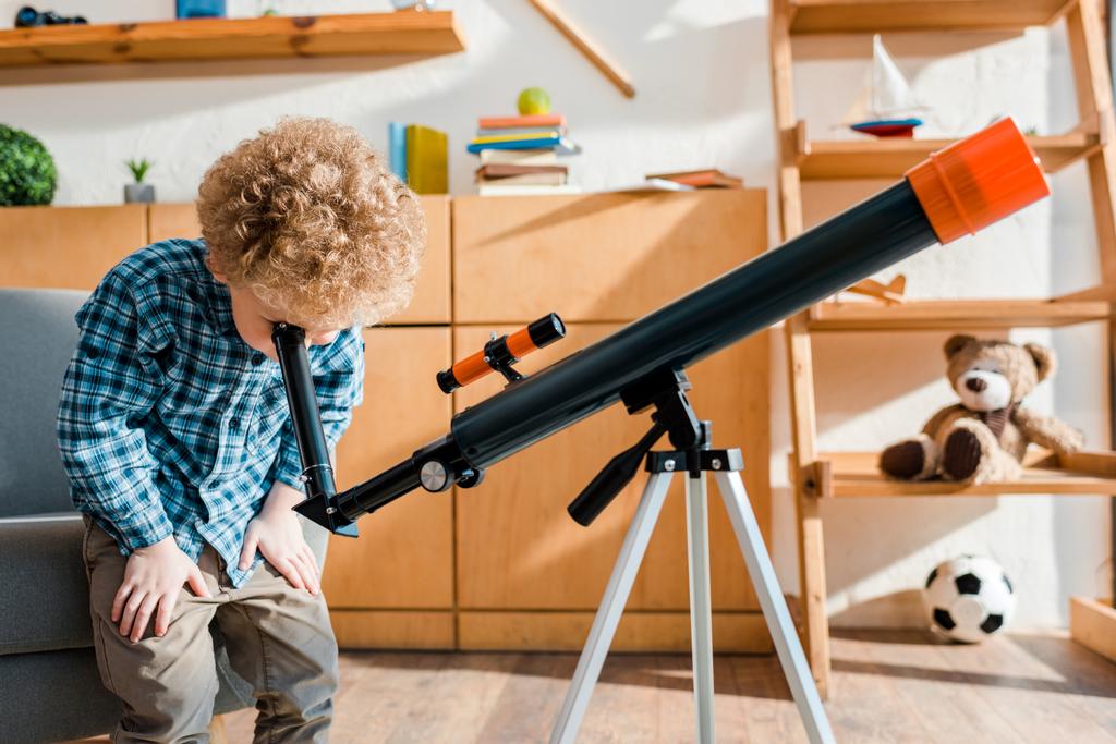 criança inteligente em camisa xadrez olhando através do telescópio
  - Foto, Imagem