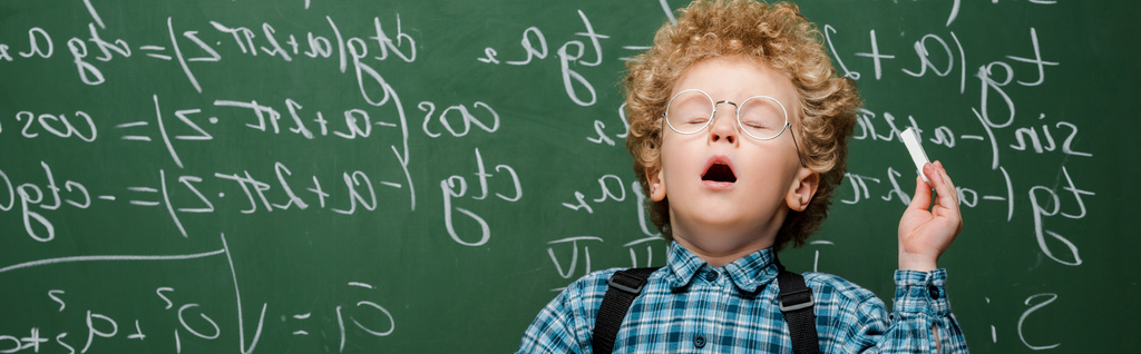 colpo panoramico di bambino riccio in occhiali starnutisce vicino a lavagna con formule matematiche
  - Foto, immagini